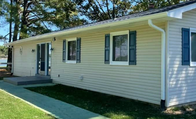 Yellow ranch home with white seamless aluminum gutters